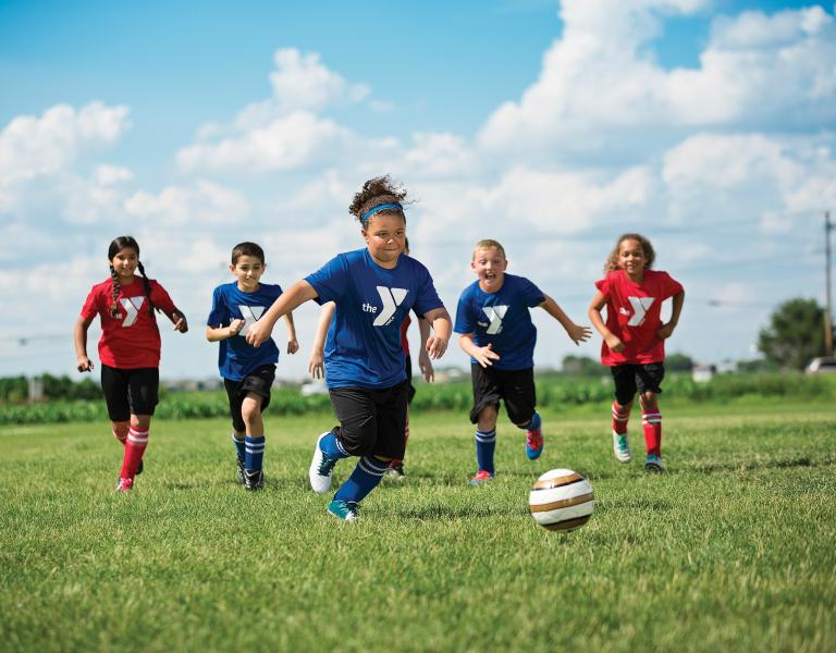 Youth soccer players running toward the ball
