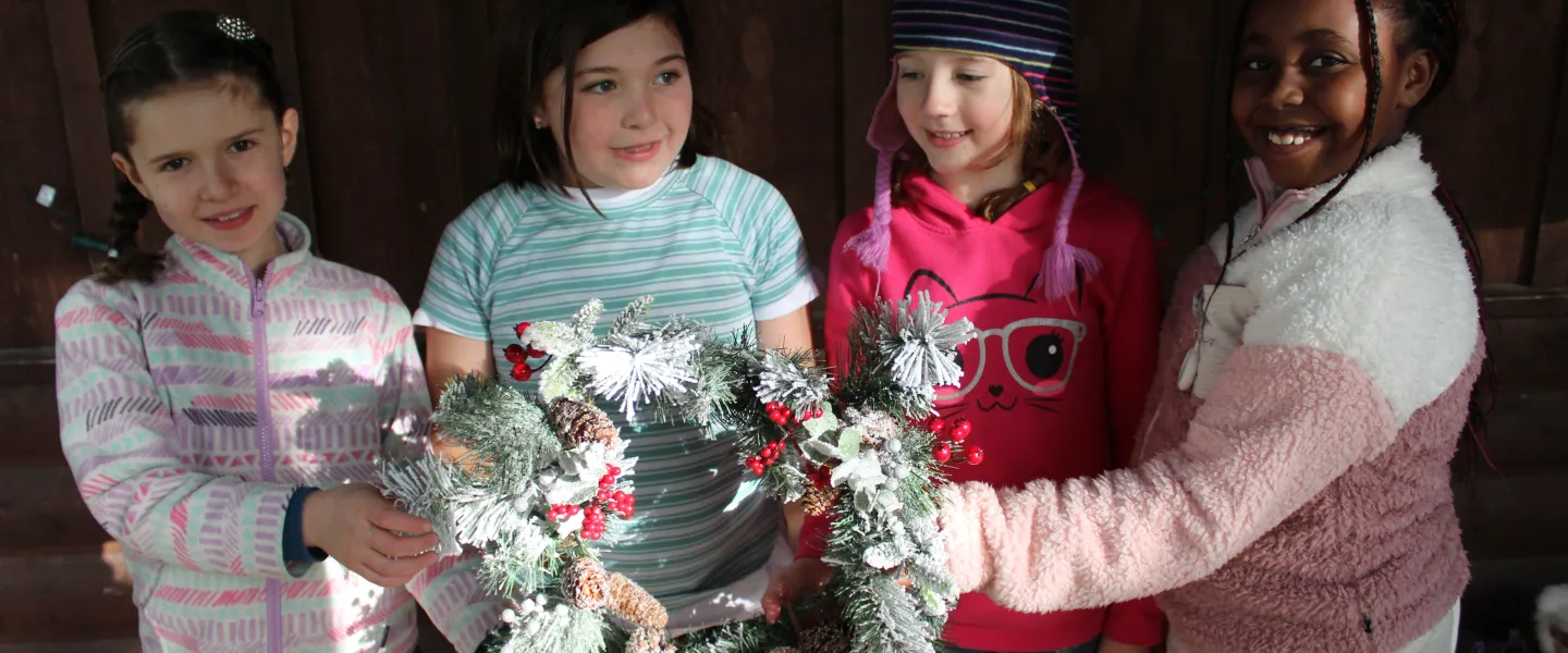 Group of campers holding a wreath