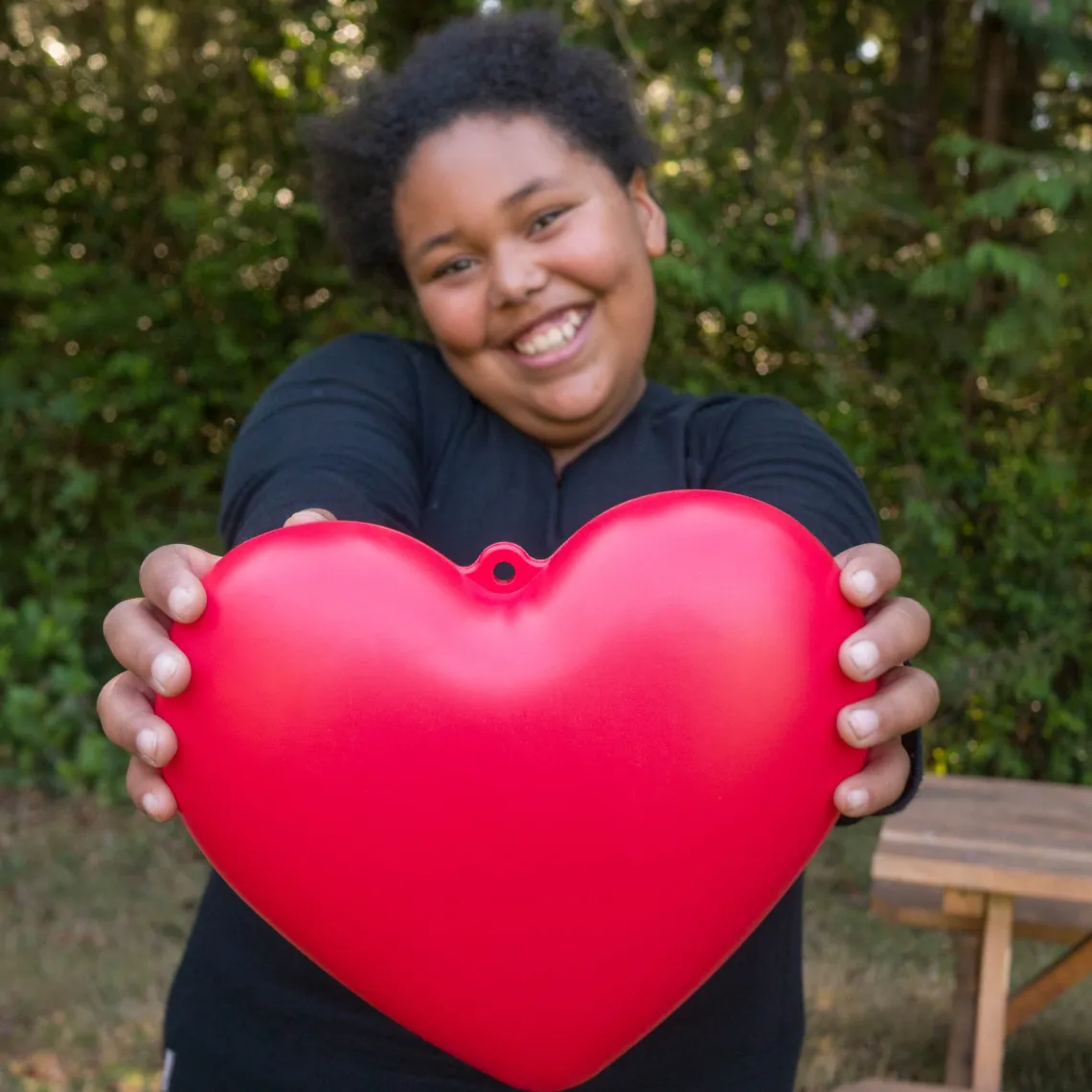 Teen camper holding a heart