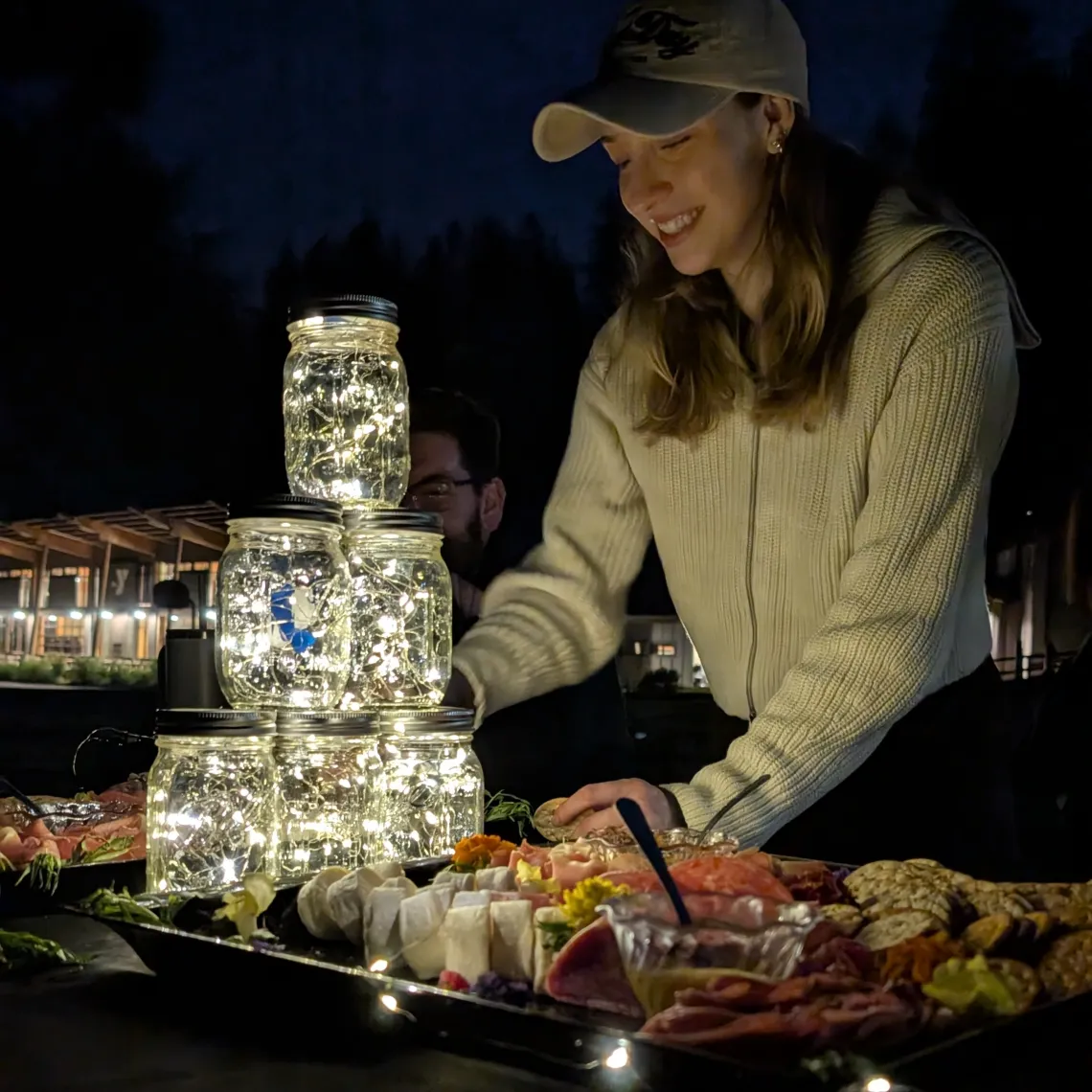 A person standing at a table with jars of lights