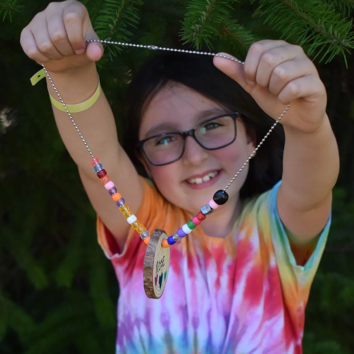 Person holding a necklace with beads and a wood cookie