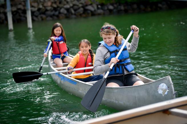 Three people paddling in a canoe