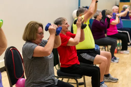 Active older adults lift weights in a senior strength class to improve balance, flexibility, strength, and stability.