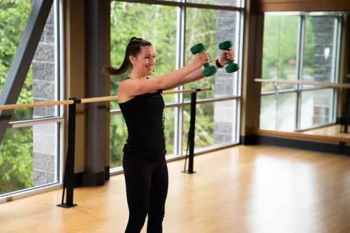A young woman works out with weights in a fitness studio at YMCA of Pierce and Kitsap Counties.