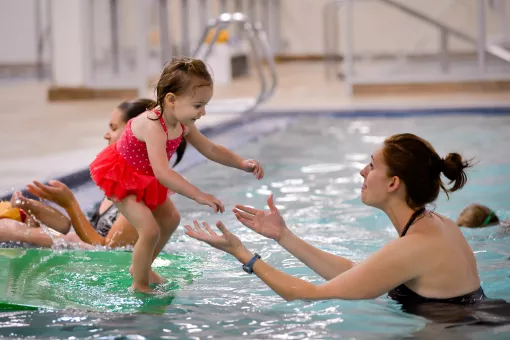 child about to jump into water during open swim