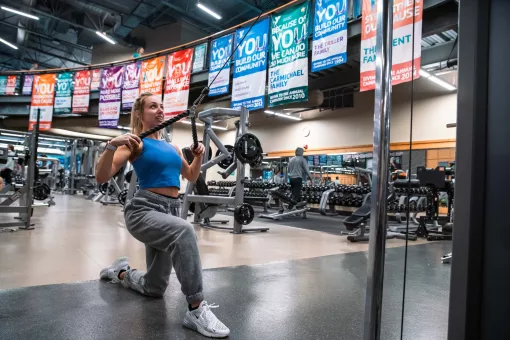 Woman doing kneeling high cable rows