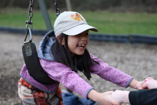 Child care participant plays on the swings at the YMCA