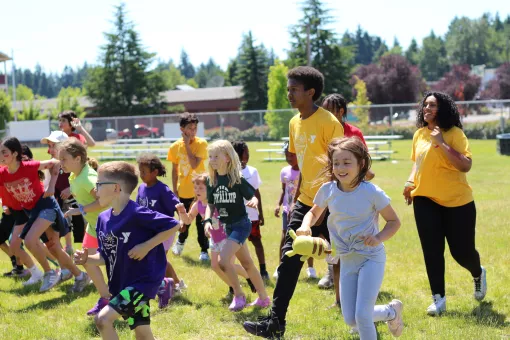 Summer Day Campers running in the field during a camptivity at the YMCA