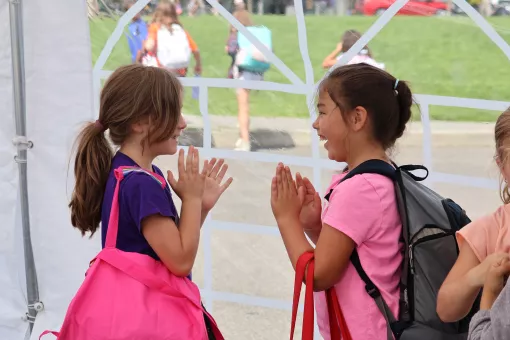 Summer camp participants engage in a fun game while waiting in line at the YMCA