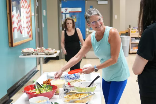 Stacey smiling as she sets up a potluck table