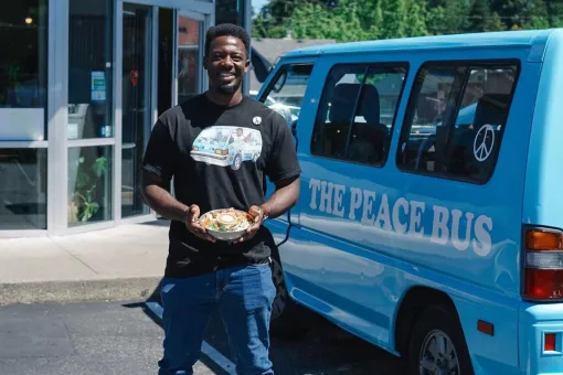 Kwabi with a salad in front of his Peace Bus