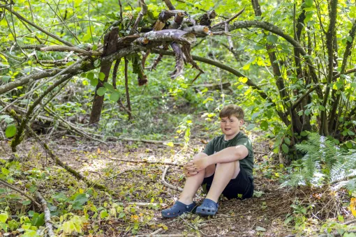 Trevor in front of a forest fort
