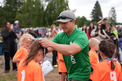 Youth Soccer Coach Giving Player a Medal