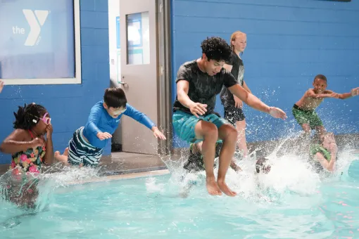 Kids jump in the pool at Y Camp at the YMCA