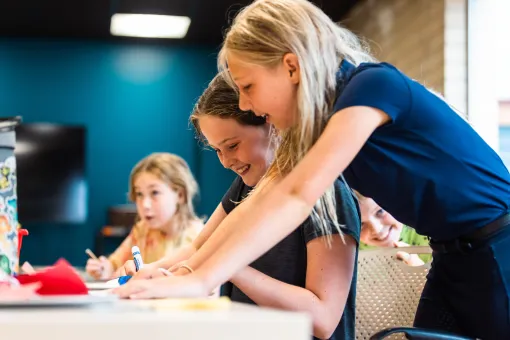 Children participate in a YMCA visual arts class, working on creative projects and collaborating during an arts education program.