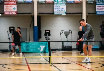 Pickleball player sets up to serve the ball at the YMCA