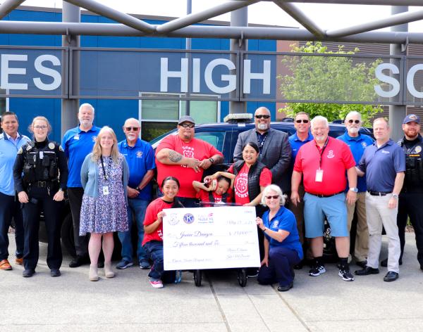 Lakewood community members smiling with a large check raised by the community and the Lakewood Police department at the YMCA