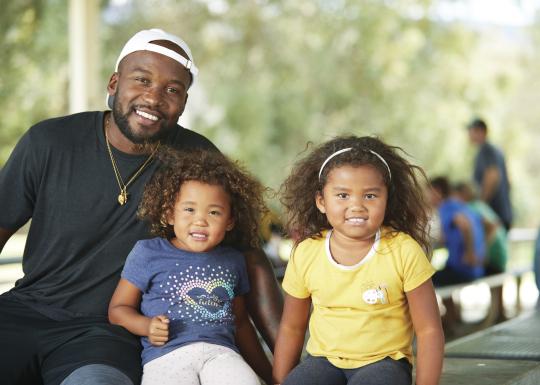 Father and two daughters outside