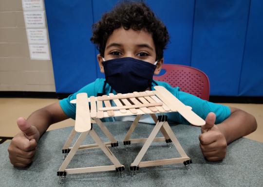 Young boy making a popsicle stick model