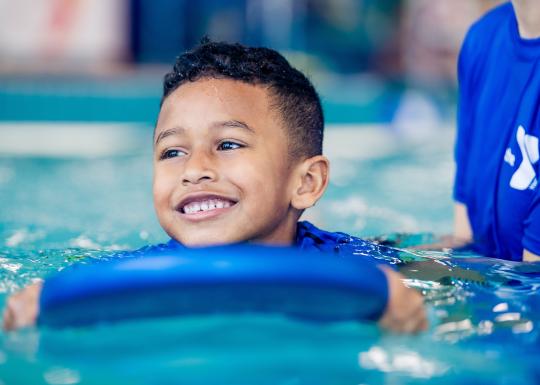 YMCA Youth Swim Lessons - Child On Paddle Board