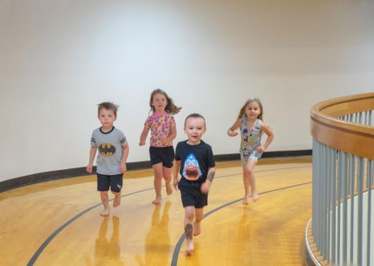 Kids Running Around Track At Their Local YMCA