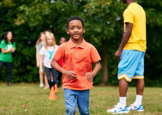 Boy Running In Field At YMCA Healthy Kids Day