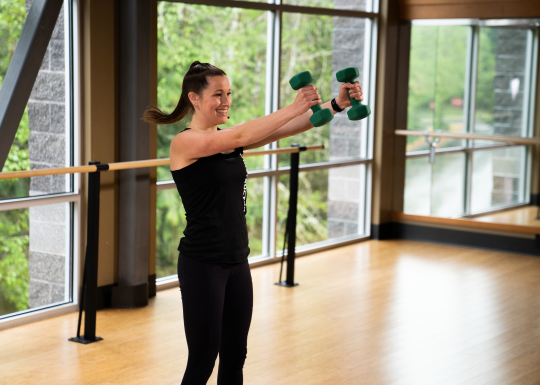 A young woman works out with weights in a fitness studio at YMCA of Pierce and Kitsap Counties.