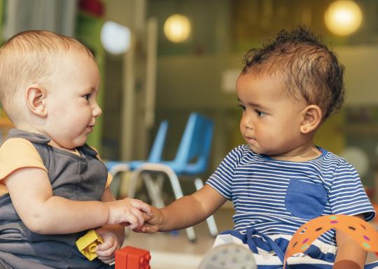 Babies shaking hands while playing