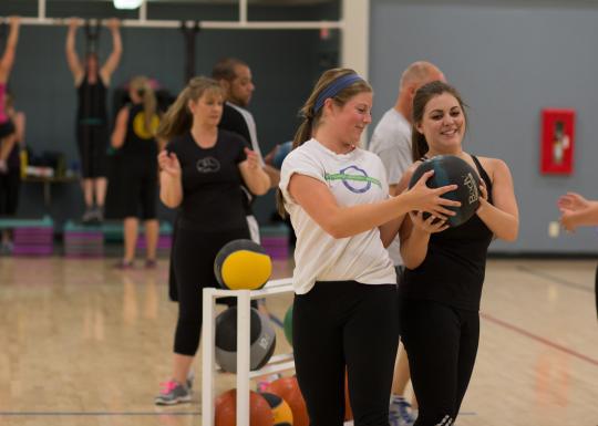 Young adults participating in medicine ball cardio activity