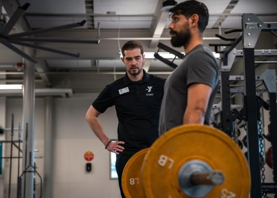 Kickstart instructor observing member implement learned deadlift form