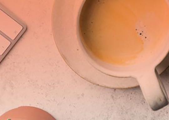 Overhead shot of a coffee mug next to a keyboard