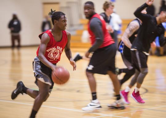 Adult Basketball player dribbling down the court mid game