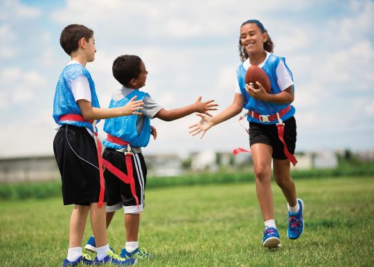 Flag football team members high five after touchdown