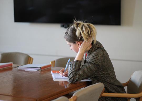 Woman taking notes in a binder