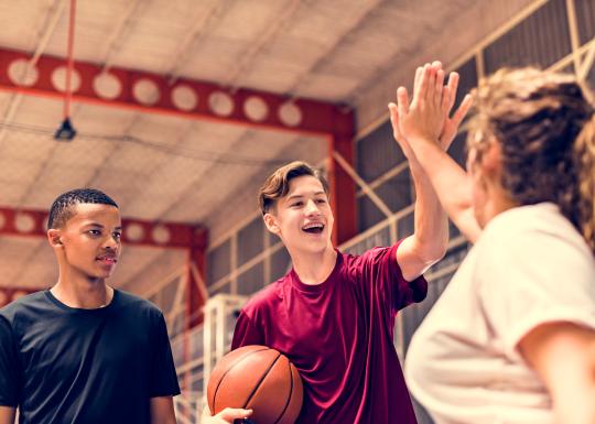 Teen Friday teens high five after a game of basketball