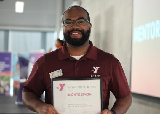 YMCA mentor of the year, Dionte Simon, smiling with his award.
