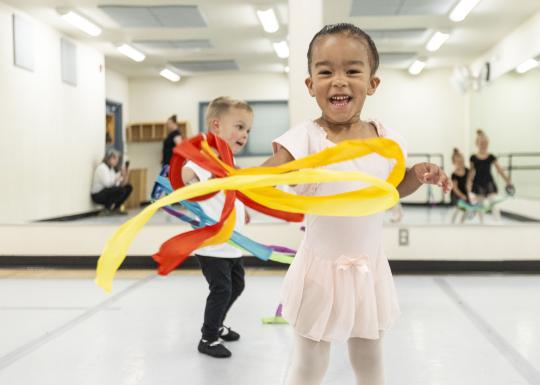 Toddler ballet students play with flow ribbons at the YMCA