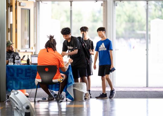 Late Nite teens check in at  the welcome desk at the YMCA