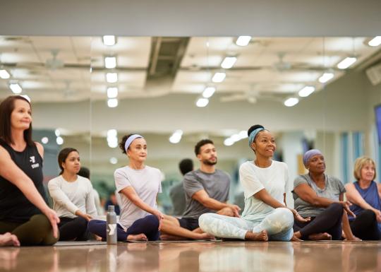 Instructor leads dance class in stretches at the YMCA