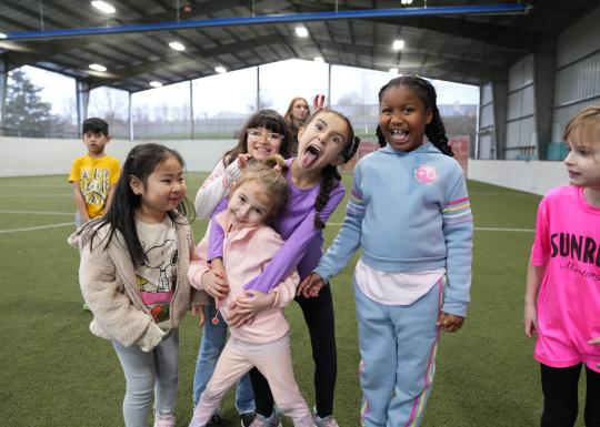 Summer Camp campers pose for a photo during turf time at the YMCA