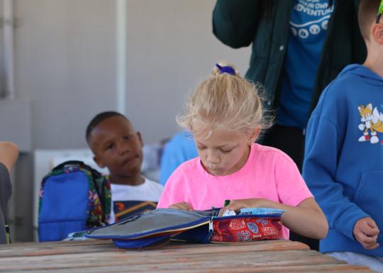 Camp participant opens their lunch during lunchtime at the YMCA