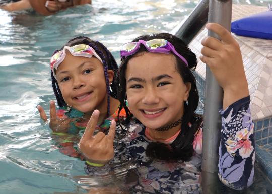 Summer camp participants pose in the pool during swimming time at the YMCA
