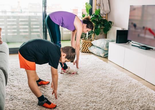 Stock photo of a mother and son exercising at home using Y360