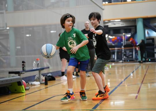 YMCA Youth Basketball Player Concentrating on the Court with Defender