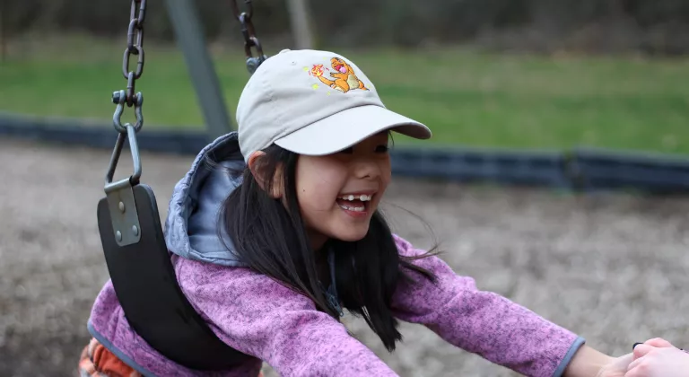 Child care participant plays on the swings at the YMCA