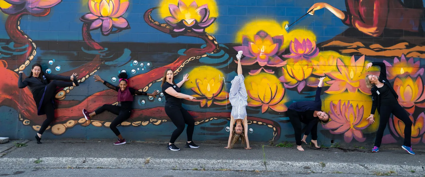 YMCA Arts Staff Having Fun In Front Of A Mural