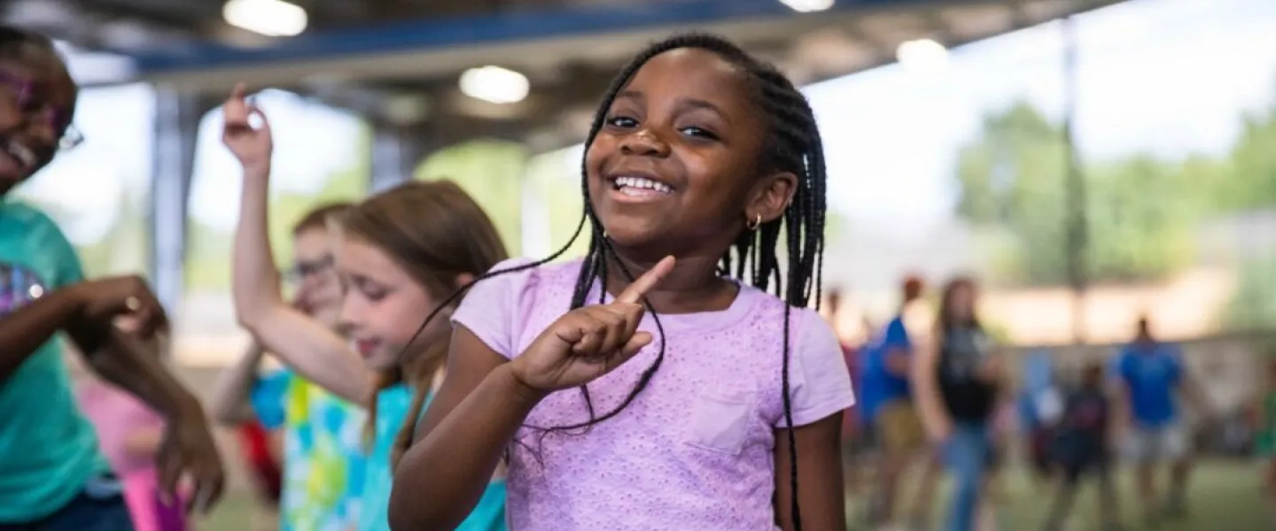 Summer camp participant celebrates a victory during game time at the YMCA