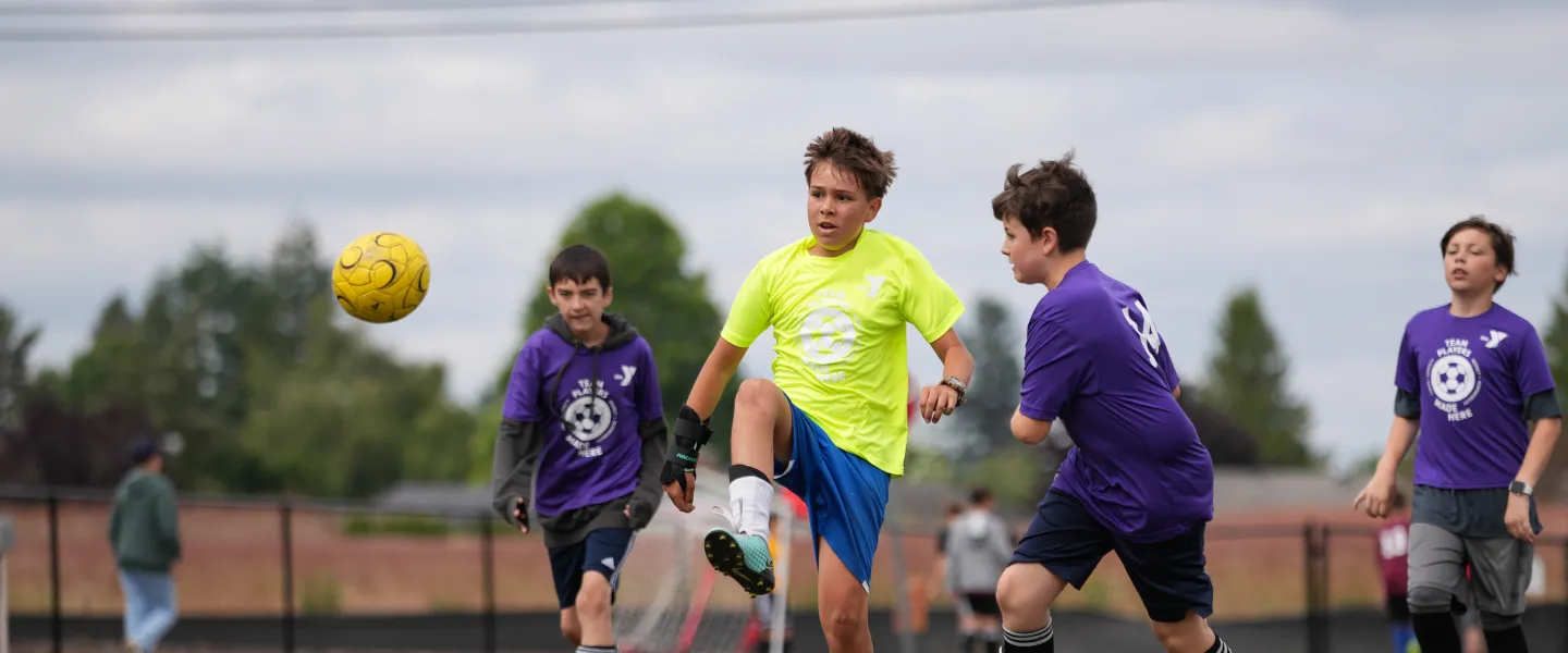 YMCA Youth Soccer League Kicking Ball into the Air