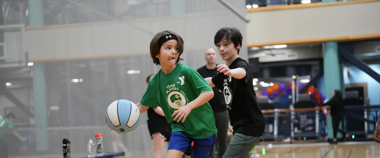 YMCA Youth Basketball Player Concentrating on the Court with Defender
