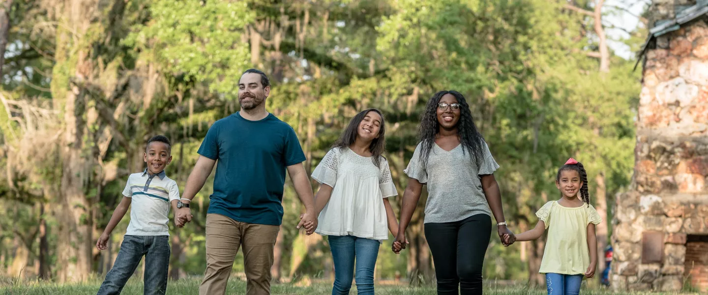 Family Holding Hands In The Park
